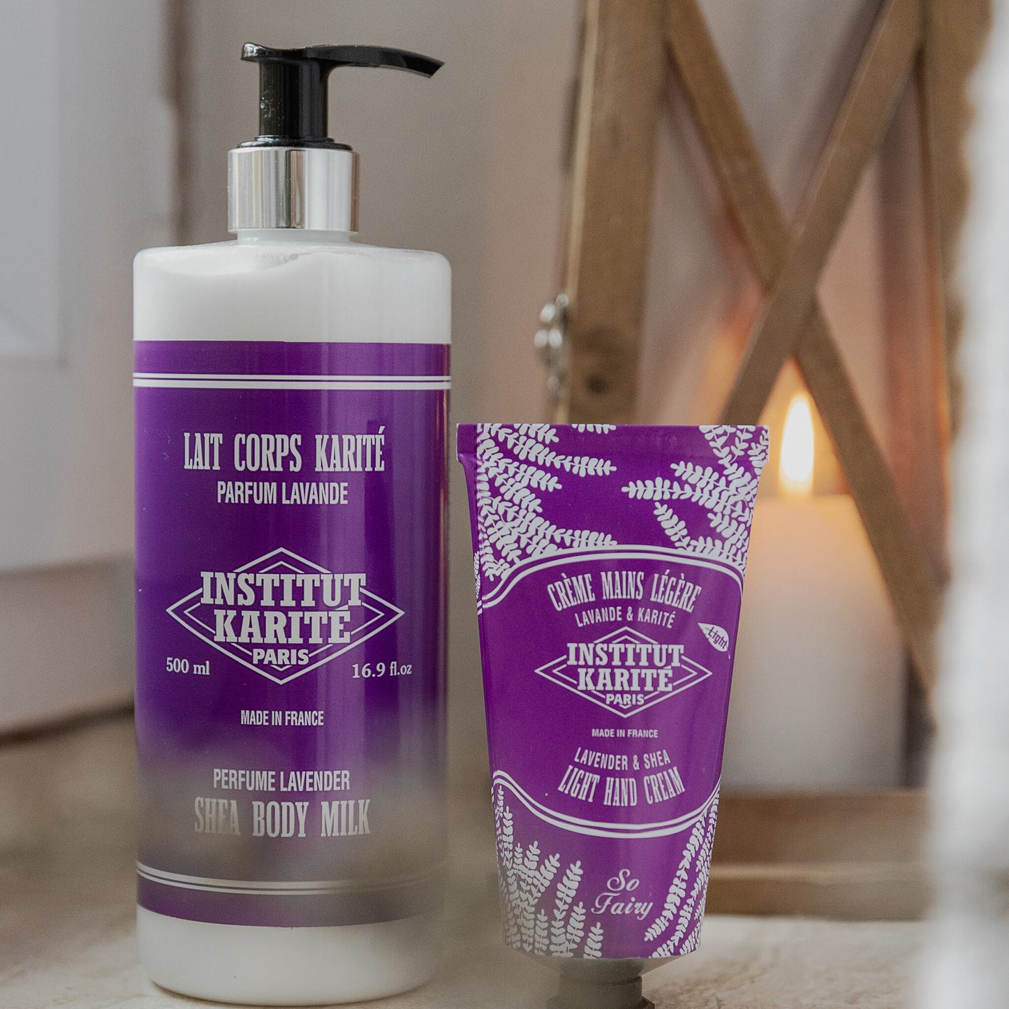 500mL Lavender Shea Body Milk beside the Lavender Light Hand Cream by Institut Karité Paris, lantern glowing behind