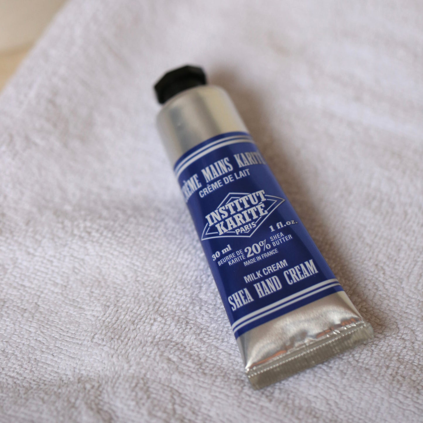 Shea Hand Cream Milk Cream 30ml tube resting on a white towel