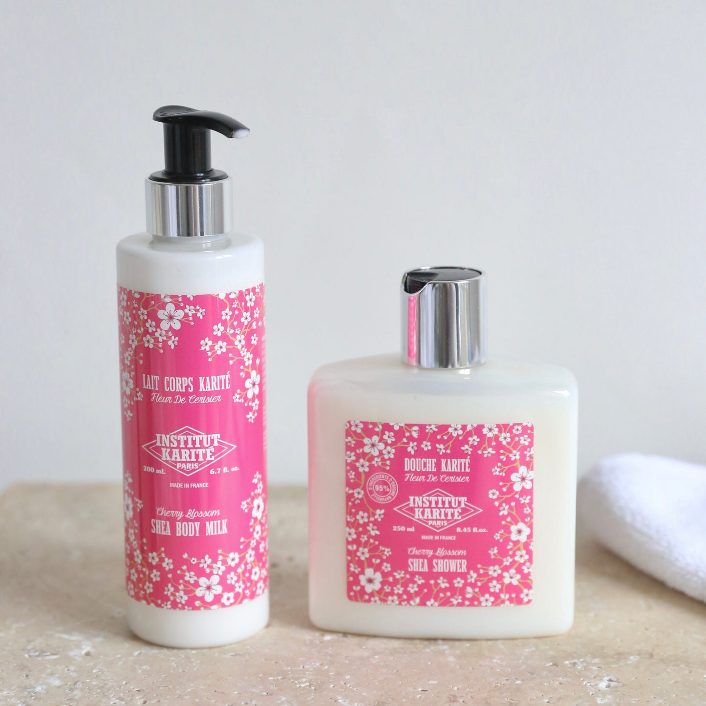 Cherry Blossom Shea Shower 250ml beside Cherry Blossom Shea Body Milk on stone