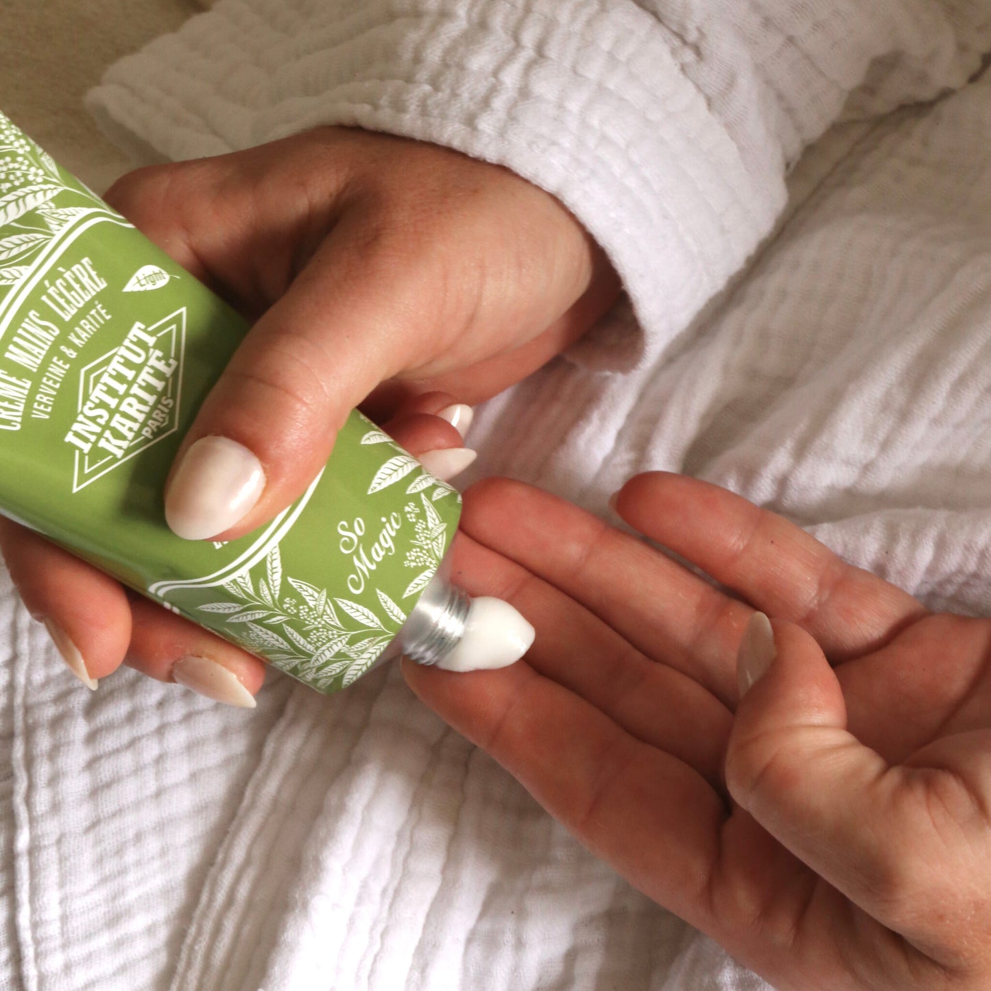Hands applying Light Hand Cream Verbena and Shea from the green tube